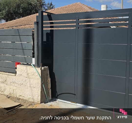גדר מתכת אפורה ליד שביל מרוצף באבנים